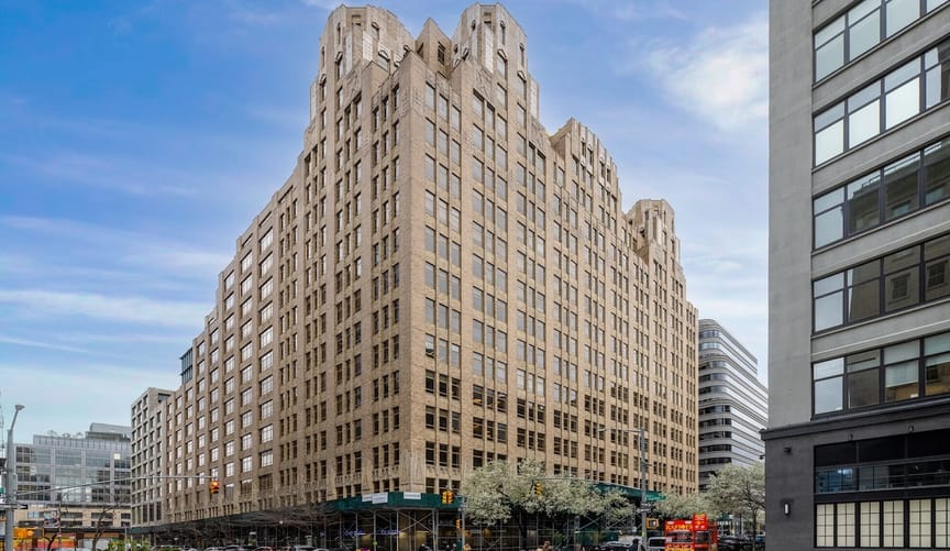 17-story beige Art Deco building in lower Manhattan at 345 Hudson St. against a blue sky.