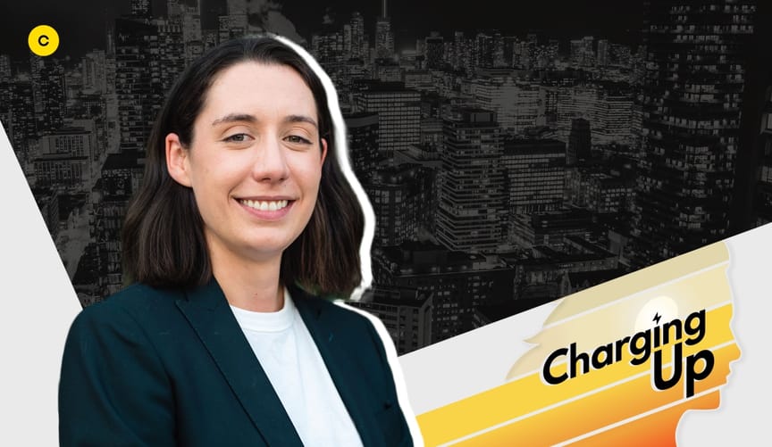 Smiling woman with light skin and brown hair, wearing a dark blazer and white shirt next to a graphic that says Charging up