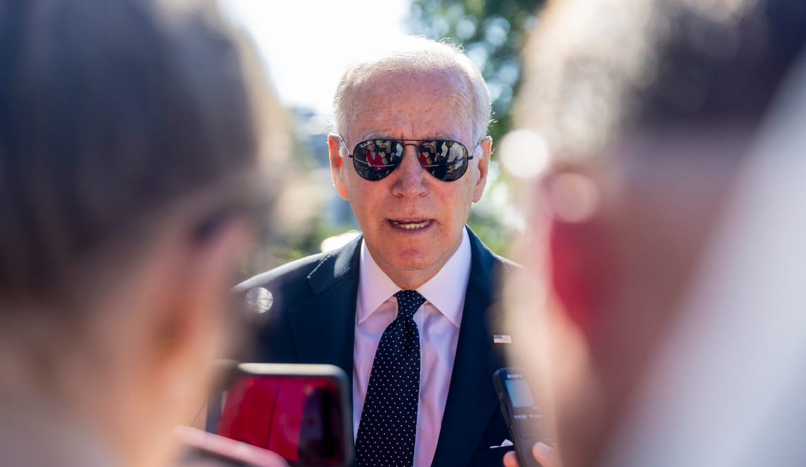 Biden in sunglasses between two anonymous people