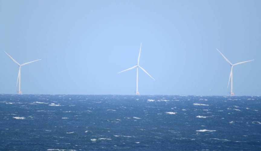 Three offshore wind turbines in the ocean