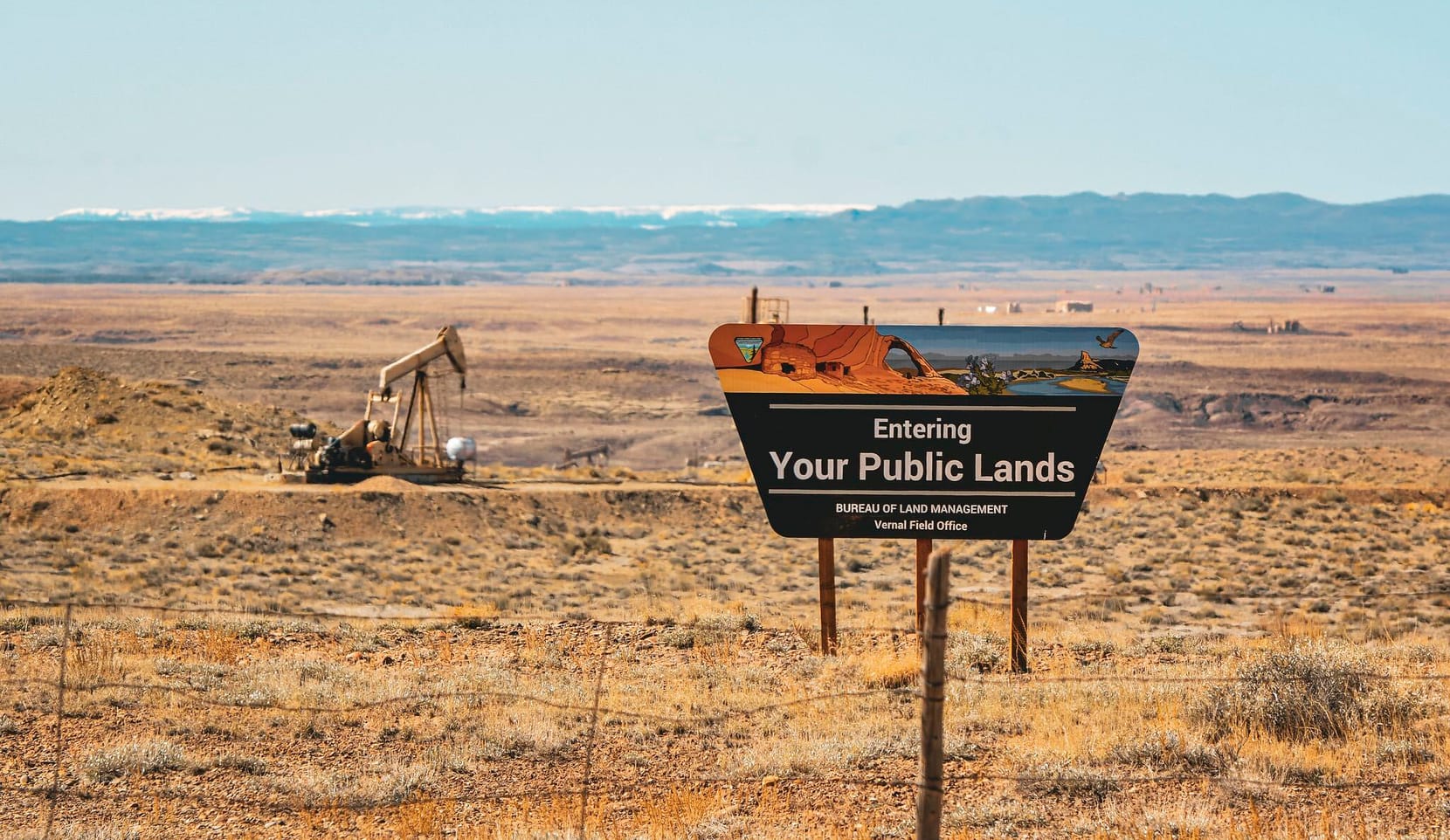 Bureau of Land Management Sign on a field with pumpjack in the background