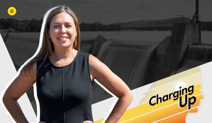 A woman with arms akimbo and long straight brown hair wearing a sleeveless black top next to a graphic that reads Charging Up