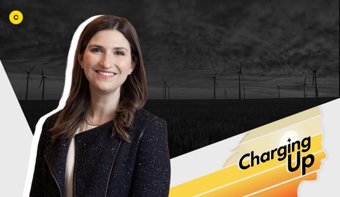 a smiling woman with brown hair wearing a black jacket next to a logo with the words "charging up"