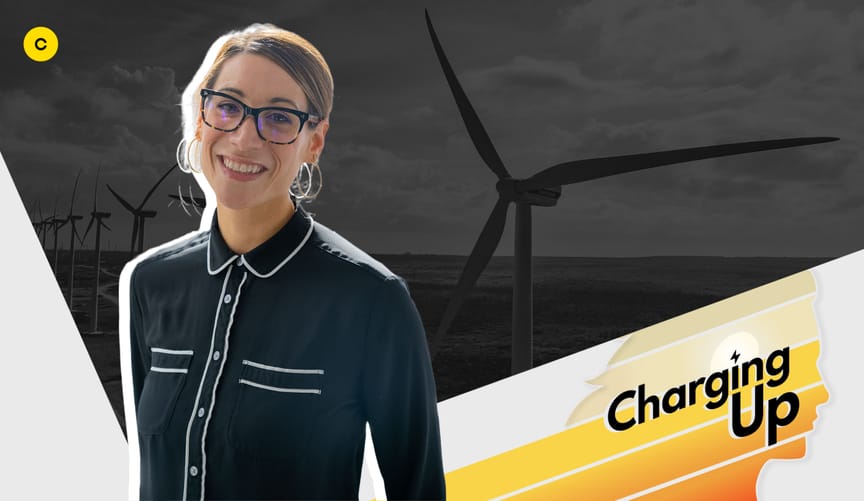 A white woman with dark hair, black glasses and a black button-up blouse next to a stylized graphic that says "Charging Up"