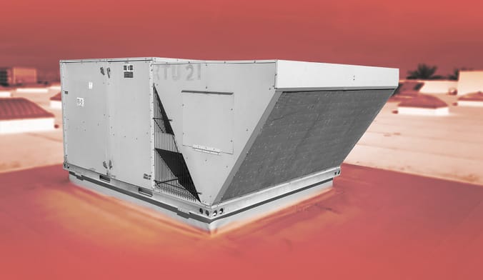 A large grey metal HVAC appliance on a rooftop. Image color-treated with red background, the appliance in true color.