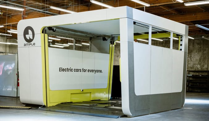 A large white metal drive-thru with the words Ample and Electric cars for everyone