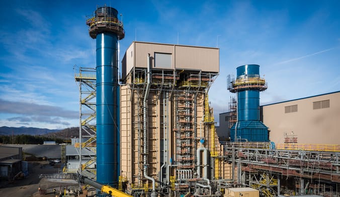 A utility plant with two tall blue cylindrical towers