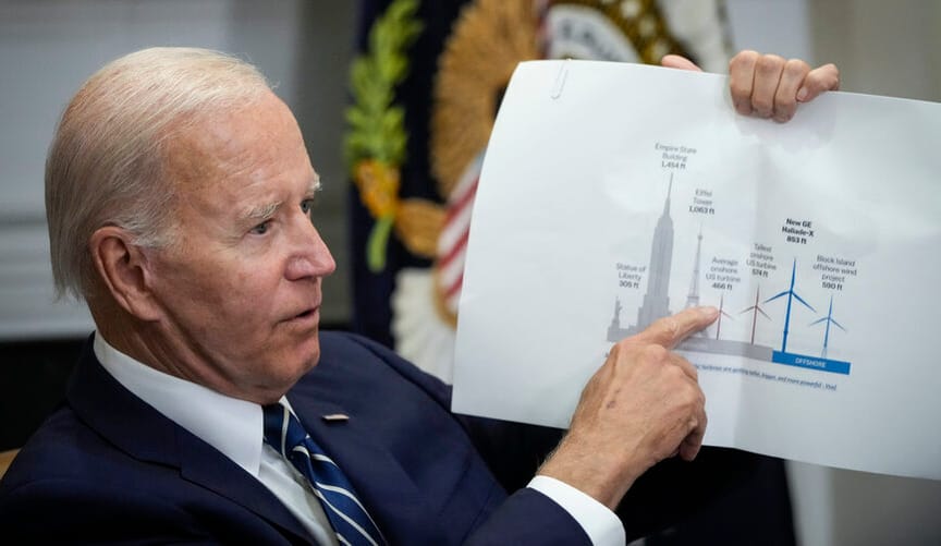 President Biden points at a chart comparing the size of offshore wind turbines to the empire state building and Eiffel Tower