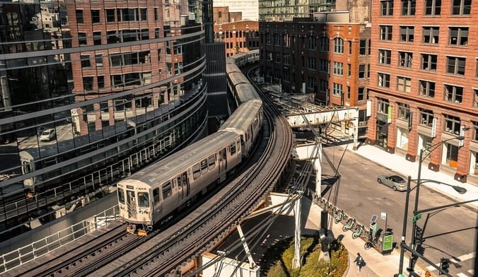 An urban Chicago neighborhood with an elevated train, commercial buildings and apartment buildings