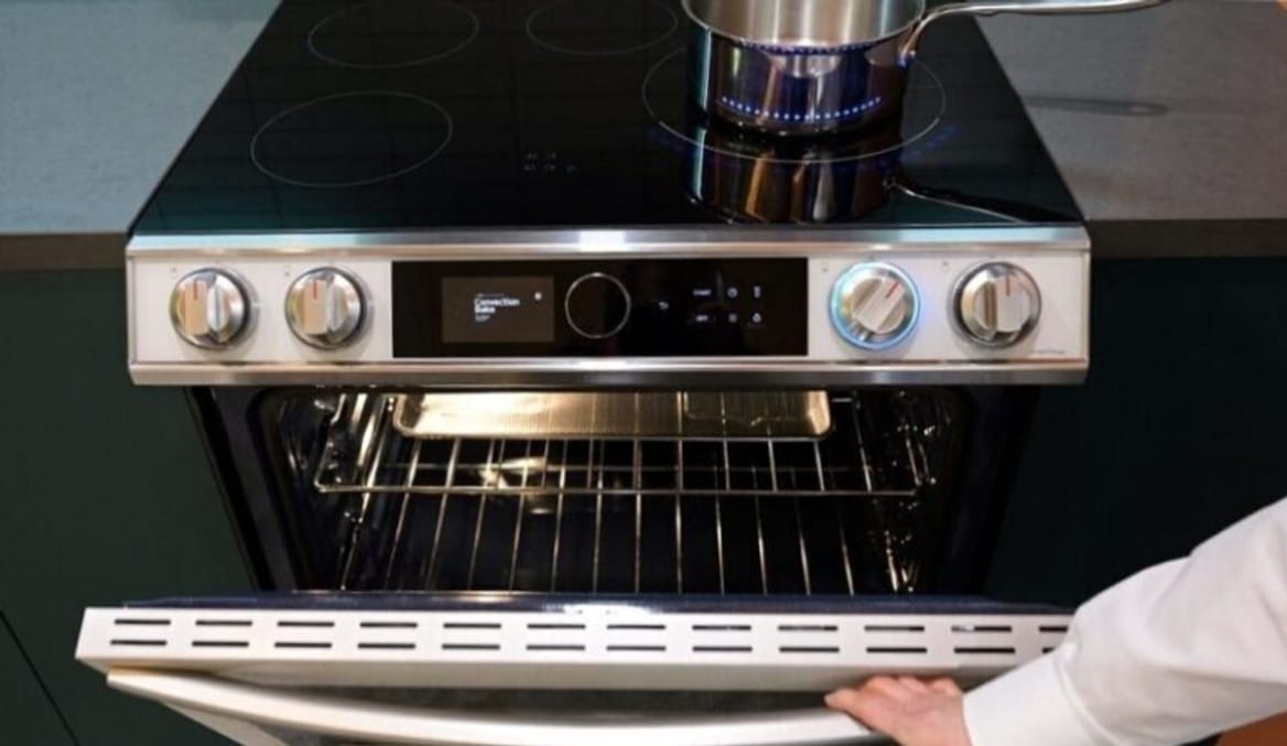 A woman's arm opens an oven door