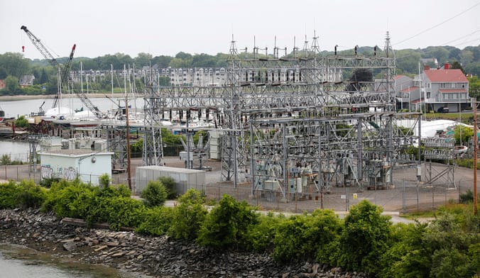 A large electrical substation next to a river