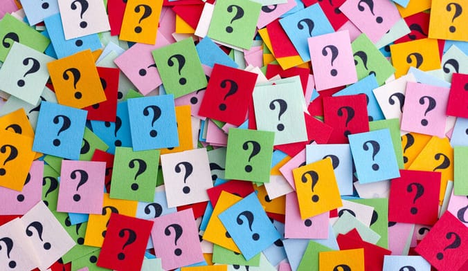 many small colorful pieces of paper with question marks