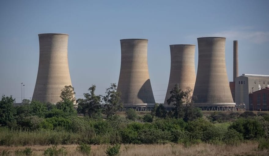 Four large concrete stacks at a coal plant