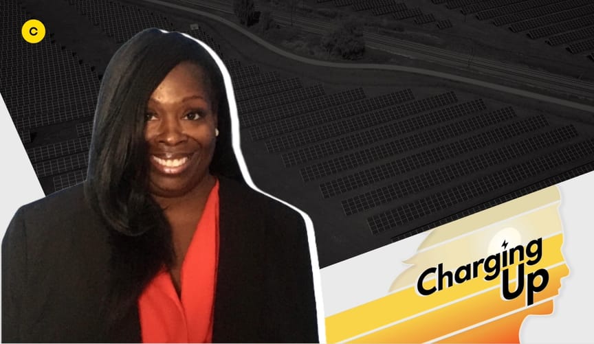 A smiling woman with below shoulder length dark hair wearing a red blouse and black jacket. The graphic reads "Charging Up."
