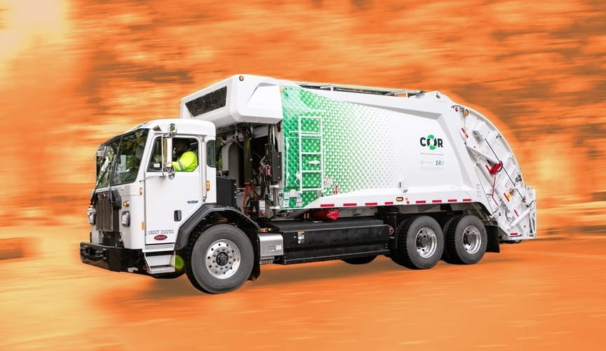 A white and green trash truck set against a bright orange background