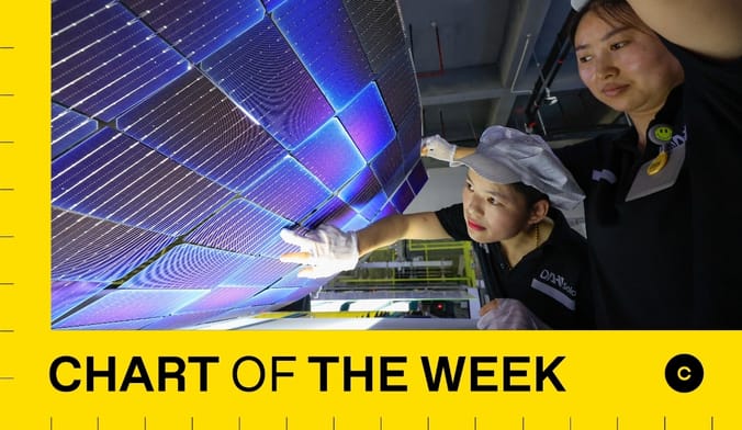 two factory workers inspect a solar panel under construction in a factory