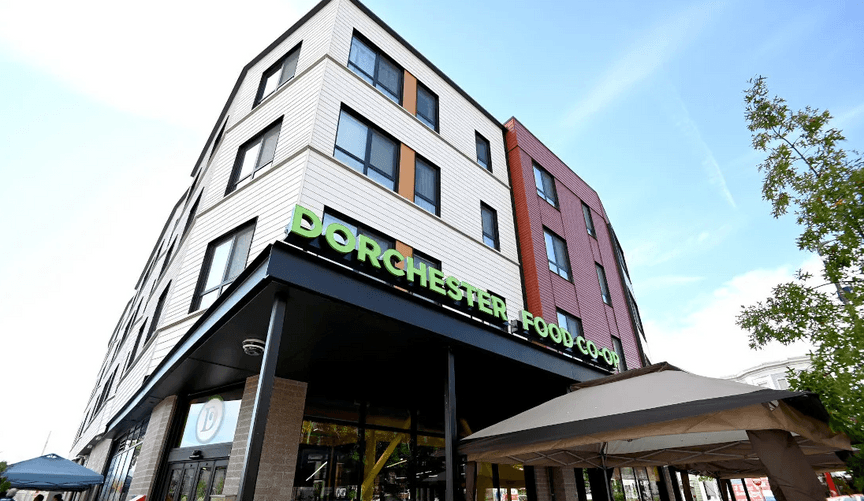 A colorful multistory building with a sign that says Dorchester Food Co-Op
