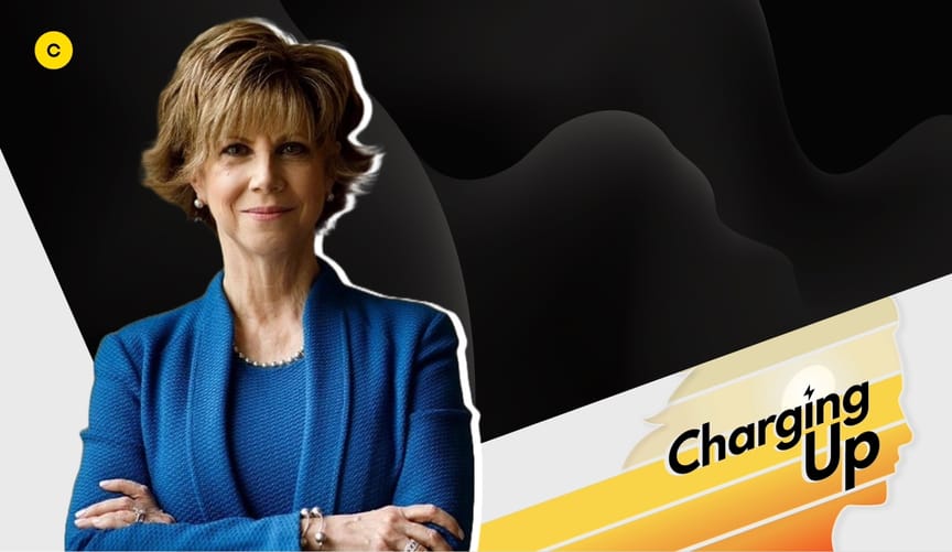 A woman with a light skin tone and short auburn hair wearing a blue blazer and blouse next to a graphic reading Charging Up