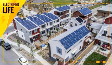 An aerial view of a modern subdivision whose houses have rooftop solar panels. A graphic overlay says ELECTRIFIED LIFE.