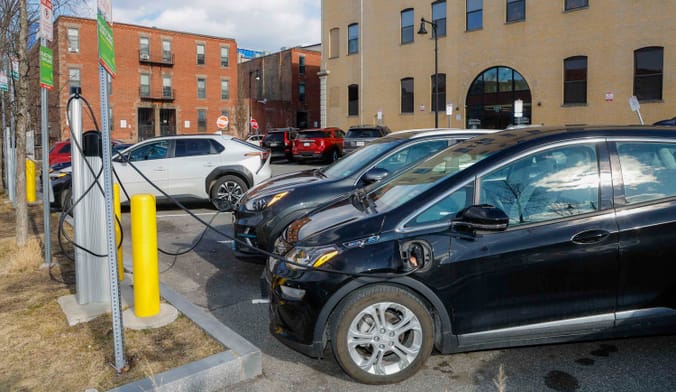 Electric vehicles plugged in to a curbside EV charging station