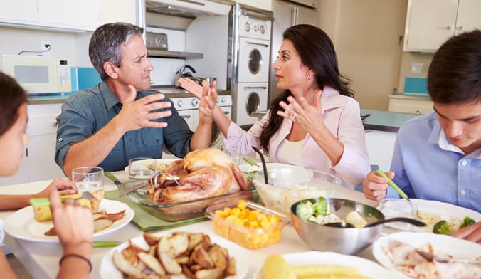a family is in a heated argument at the table for thanksgiving dinner