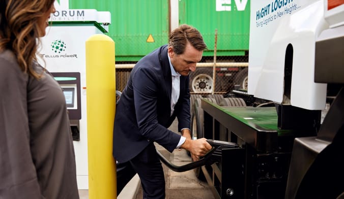 A man inserts a charger into an electric truck