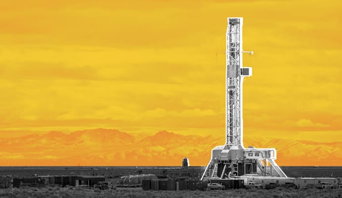 A tall narrow industrial structure set against a yellow-gold graphic backdrop