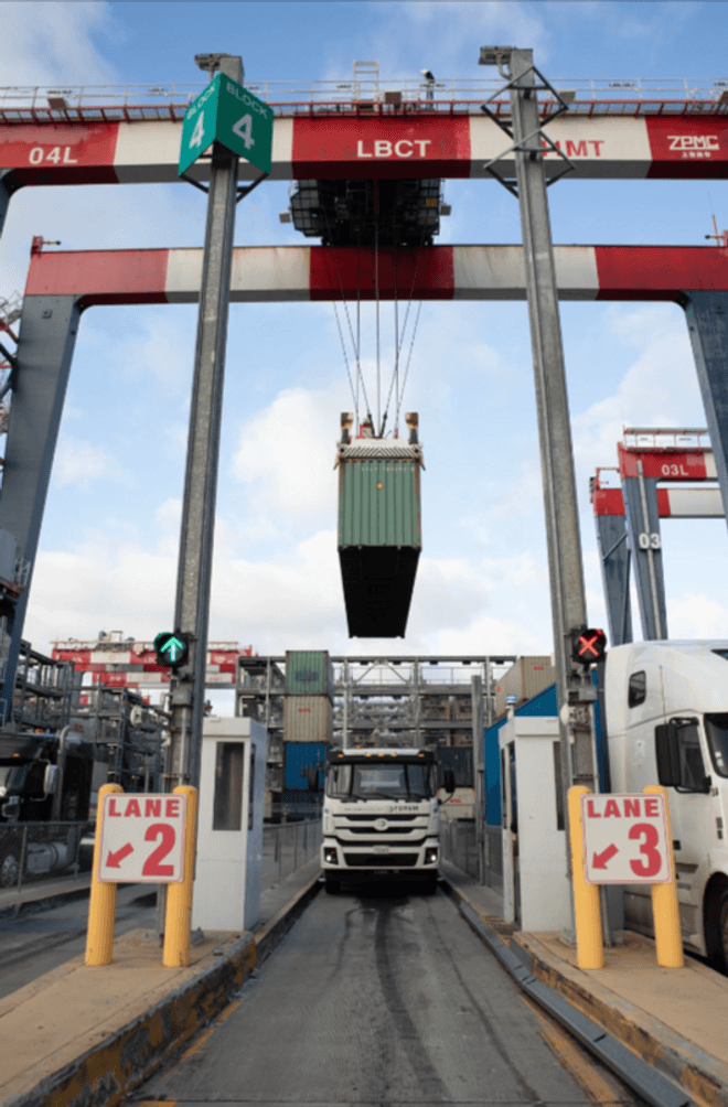 Drayage trucks sit in lanes at a port