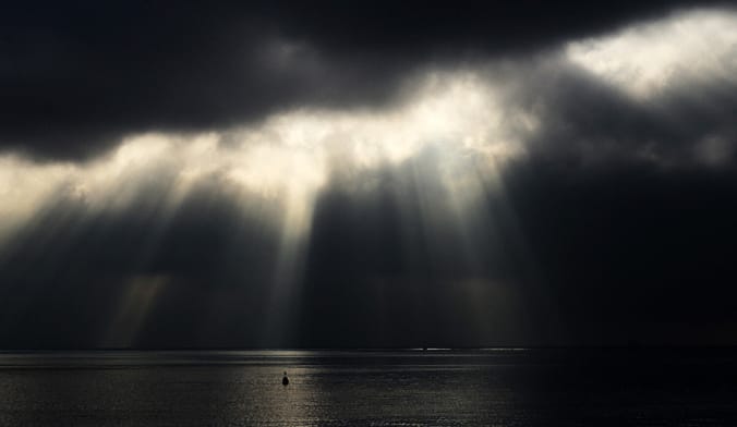 Light shining through dark stormy clouds
