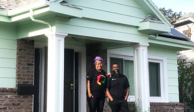 Oakland homeowner Cheryl Ajirotutu and Mark Hall, CEO of Revalue.io, in front of Ajirotutu's all-electric home