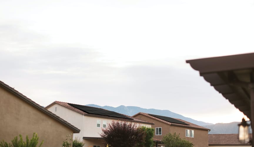 A neighborhood with several houses with solar panels on their rooftops