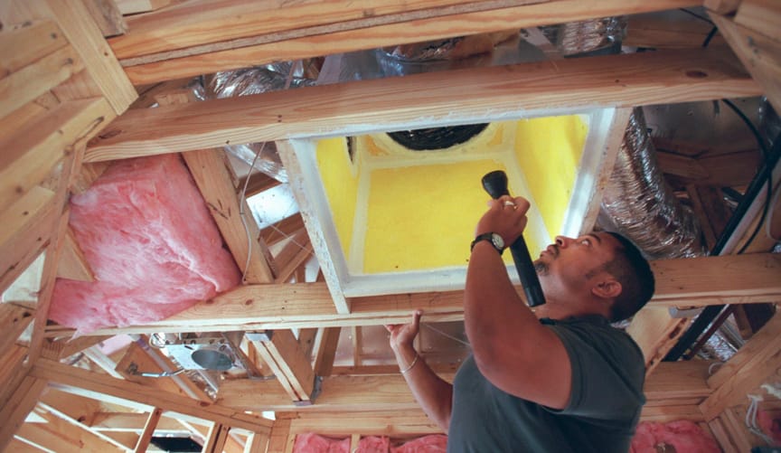 A contractor inspects an air return in the heating an cooling system of house being built by Emerald Homes in Cinco Ranch
