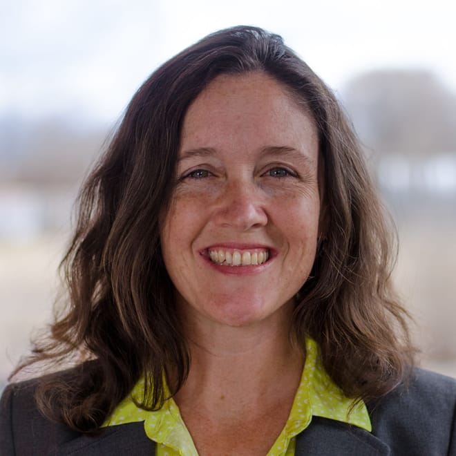 A smiling woman with shoulder-length brown hair