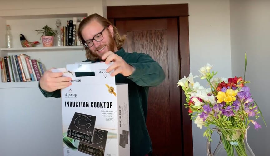 man opening box with induction cooktop