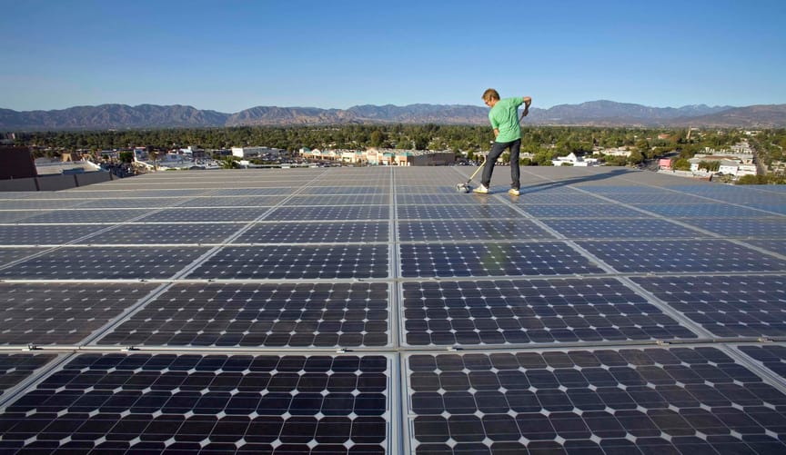 Rooftop solar array with a person cleaning the panels in Los Angeles, CA.