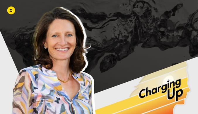 A woman with light skin and shoulder length wavy brown hair wearing a multicolored blouse. A graphic says Charging Up