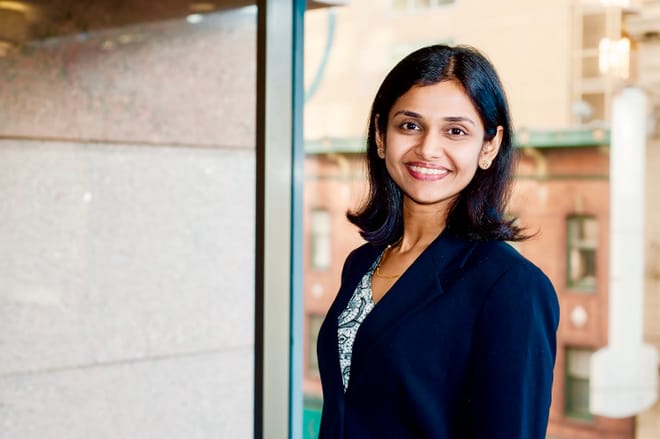 A smiling woman with dark, shoulder-length hair and a dark blazer