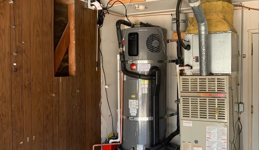 A Rheem ProTerra 120-volt heat pump water heater plugged in next to a furnace