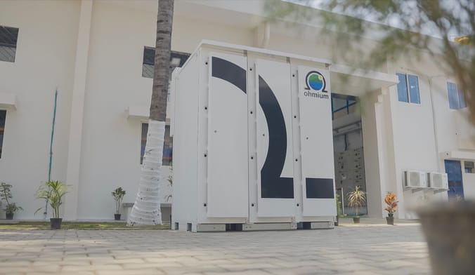 A large white metal box stands in front of an office building