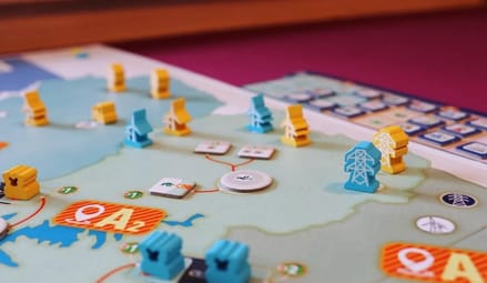 Colorful board game with tiny electrical towers, wind turbines, and electrical transformers.