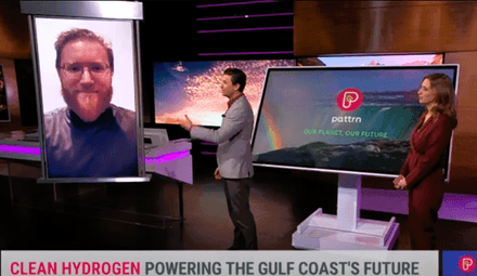 Two TV hosts, one male and one female, engage in a video chat with a reporter with light red hair, glasses and a beard.