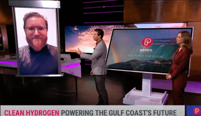 Two TV hosts, one male and one female, engage in a video chat with a reporter with light red hair, glasses and a beard.