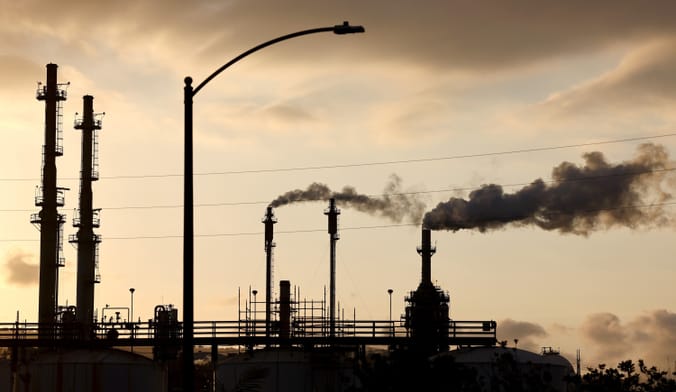 A refinery plant is seen with smokestacks