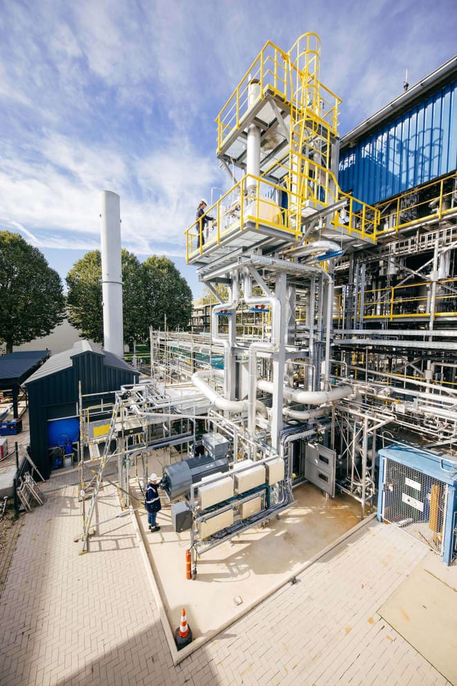 A large industrial facility with many blue and yellow pipes