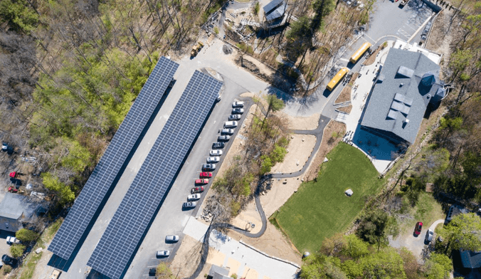 An aerial view of a parking lot with solar panels