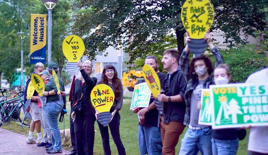 activists holding "Pine Tree Power" signs