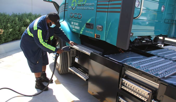 A driver recharging a Volvo VNR Electric truck