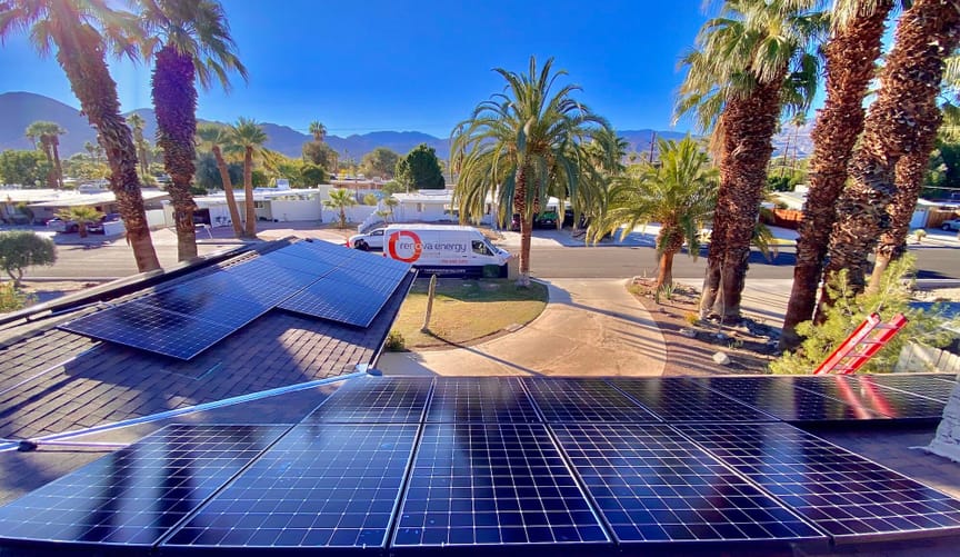 A Renova van sits in front of a house with solar panels surrounded by palm trees in California’s Coachella Valley