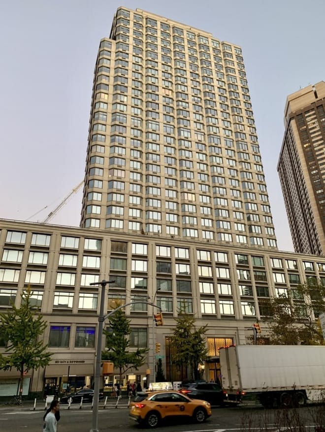 a large high-rise apartment building on a bustling city street