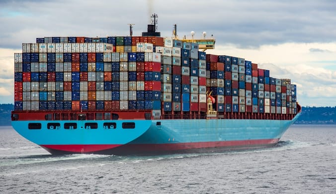 A cargo ship packed high with colorful containers
